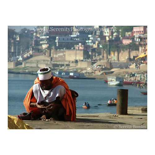 A holy man sits on the ghats, overlooking the Ganges. Varanasi, India